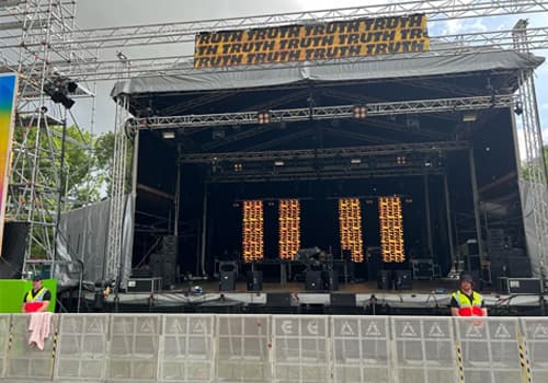 A festival stage, with a steward in a high-visibility jacket at the barrier